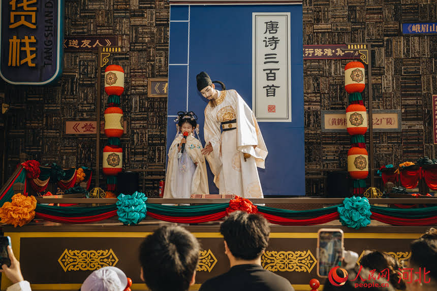 5月18日，河北唐山河头老街NPC“李白”正在景区内与围拢的小游客吟诗作对。人民网记者 商帆摄